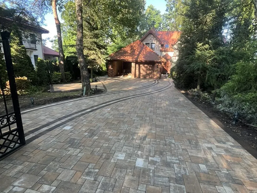 Schody wejściowe z ciemnych płyt gresowych z kratką wycieraczki przy drzwiach